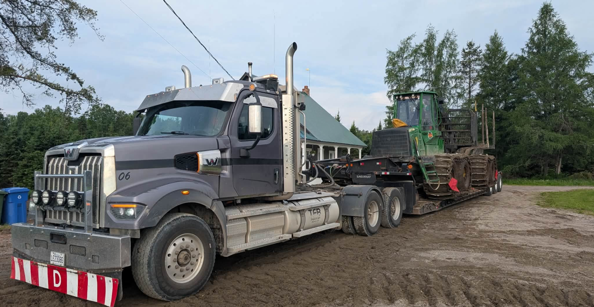 Western Star TFB avec fardier transportant une débusqueuse John Deere